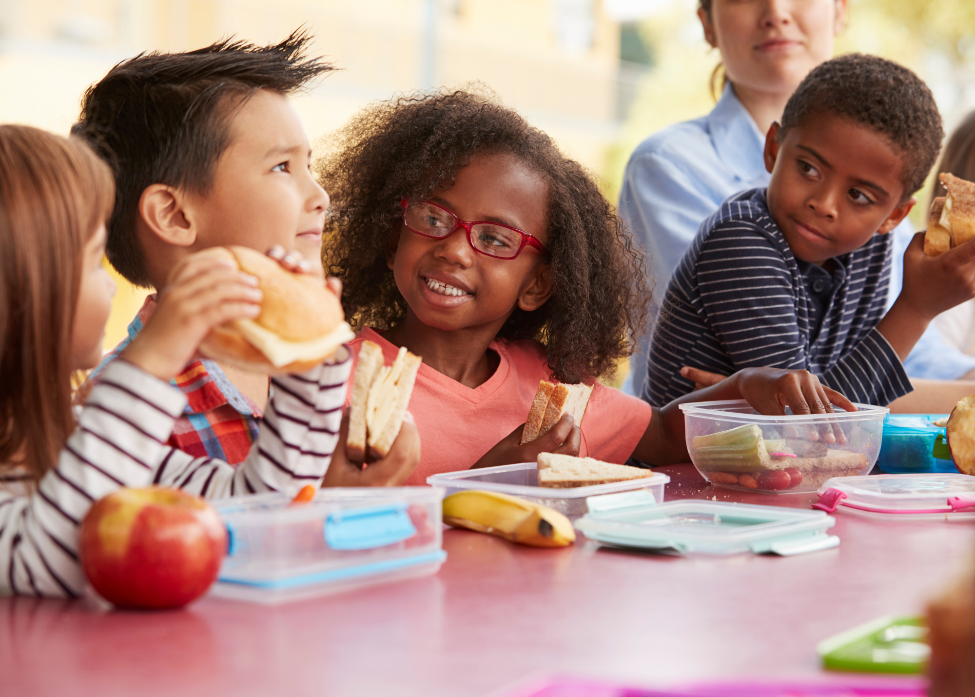 A group of children sitting around a table eating food